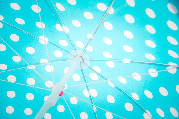 Close upward view of a blue dotted beach umbrella