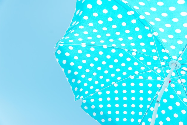 Close upward view of a blue dotted beach umbrella