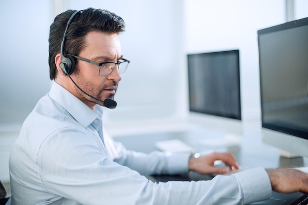 Close-upzakenman met een headset werkt in een modern kantoormensen en technologie