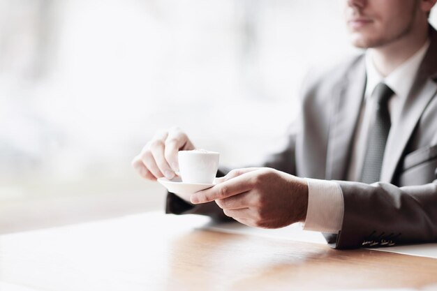 Close-upzakenman met een kopje koffie aan zijn bureau