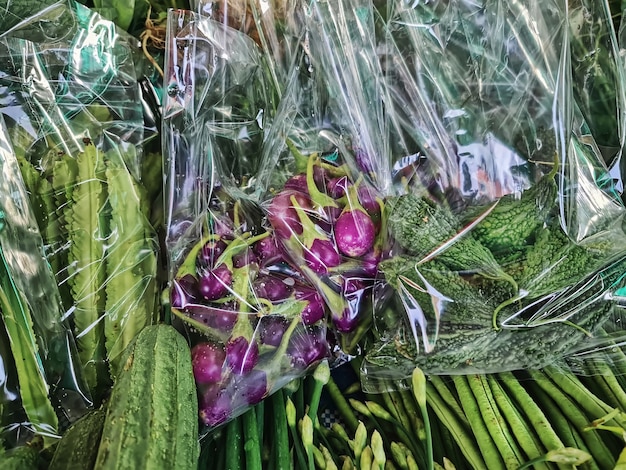 Close-upzakken met paarse aubergines en bittere kalebassen te koop