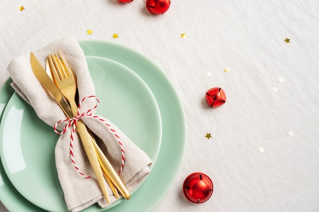 Close view of golden cutlery on light napkin for Christmas table setting