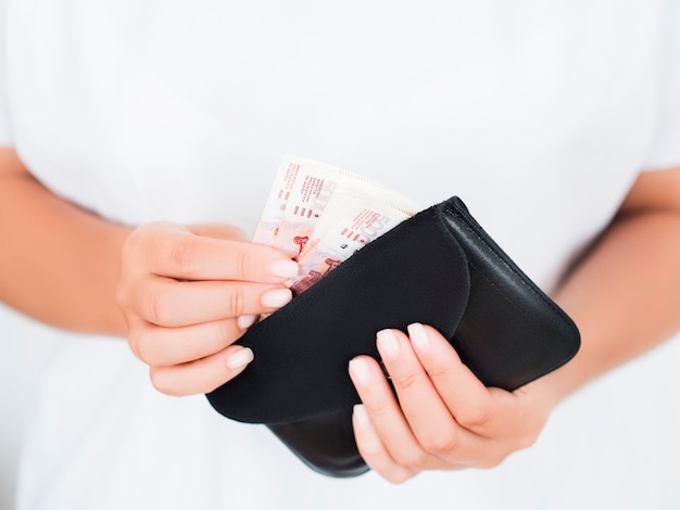 Close view of hands woman holding pile of rubles in wallet