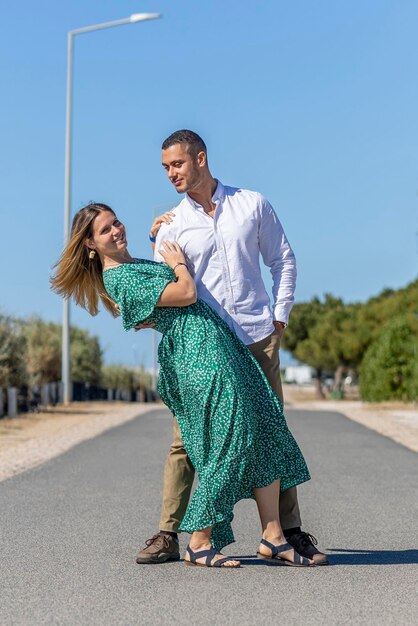 Close view of a happy young European couple holding together on a asphalt road