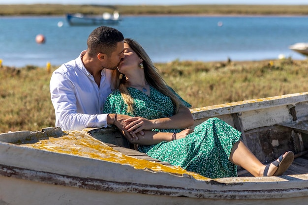 Close view of a happy young european couple holding together next to wooden boat