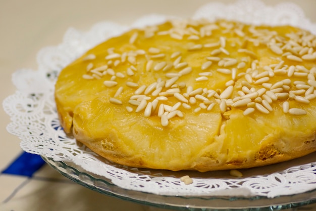 Close view of a homemage pineapple cake decorated with pine nuts.