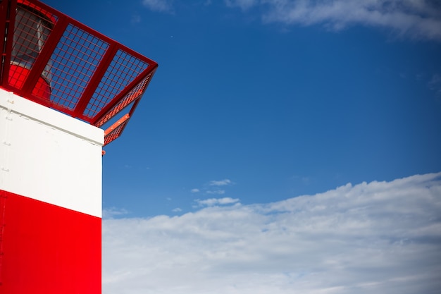 Close view of the lighthouse on the of blue sky.