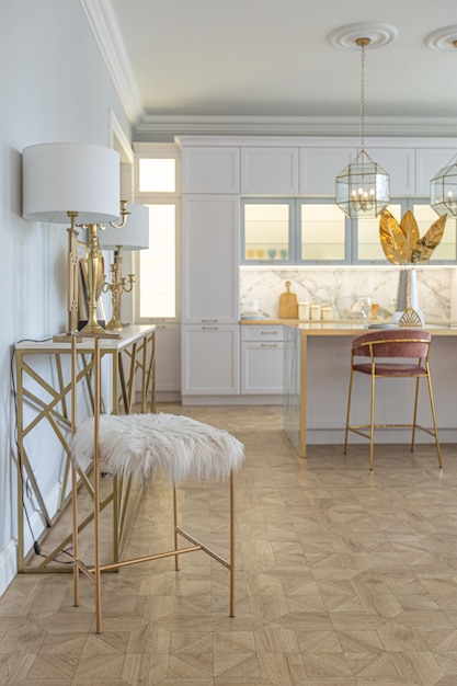 A close view of the white stylish kitchen with a cooking island in the luxurious interior of a modern apartment in light colors with stylish furniture