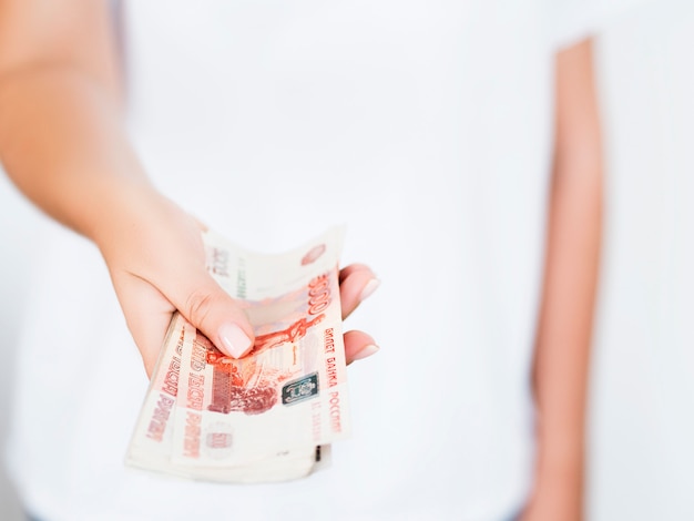 Close view of woman holding pile of rubles