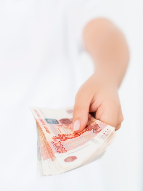 Close view of woman holding pile of rubles