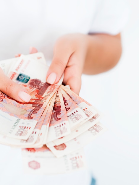 Close view of woman holding pile of rubles