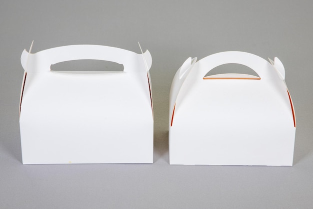 Foto 2 scatole di cartone bianche chiuse due scatole di pasticceria bianche scatole di trasporto torte isolate