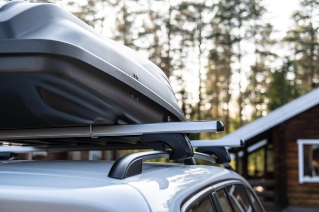 Closed assembled roomy trunk or cargo box on the roof of the car before a family vacation