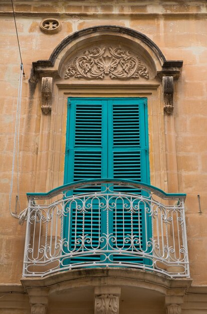 Closed blue window shutters and a small balcony in Malta