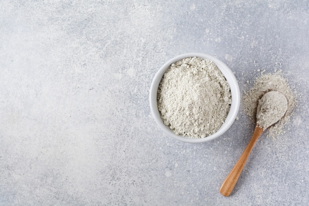 Closed collagen in a ceramic bowl on an old gray concrete table. Flat lay with copy space.