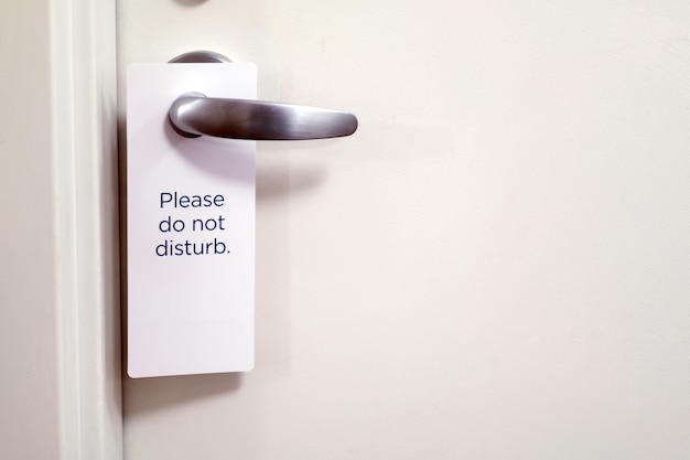 Photo closed door of hotel room with please do not disturb sign