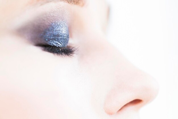 Closed eye of a young girl with shiny eyeshadow