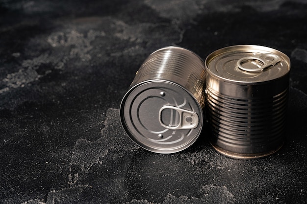 Closed food tin cans on dark background