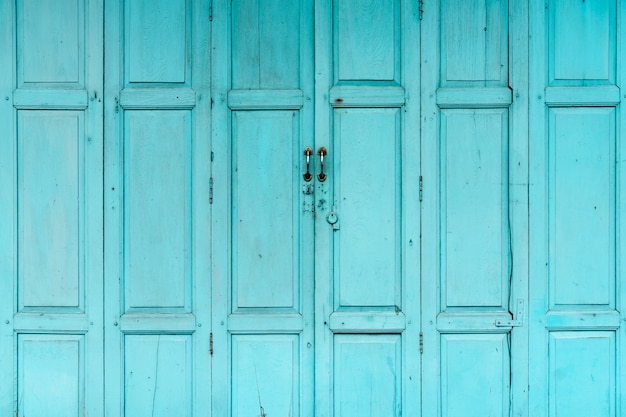 Закрытая зеленая или синяя деревянная дверь. старинный парадный вход абстрактный фон. заброшенный старый дом.