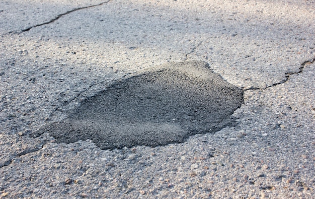 Closed hole in the asphalt roadRepaired automobile asphalt road