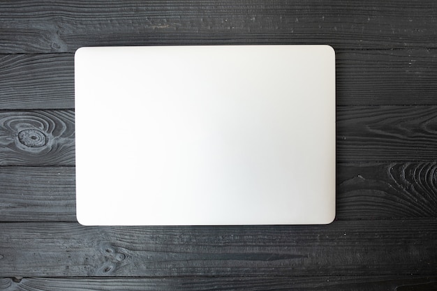 Closed laptop on a wooden background