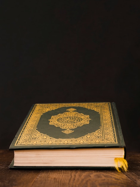 Closed quran on a table with black background