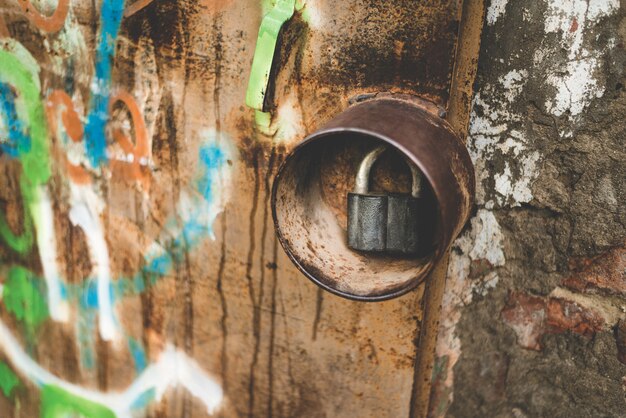 Closed rusted lock on an old iron door