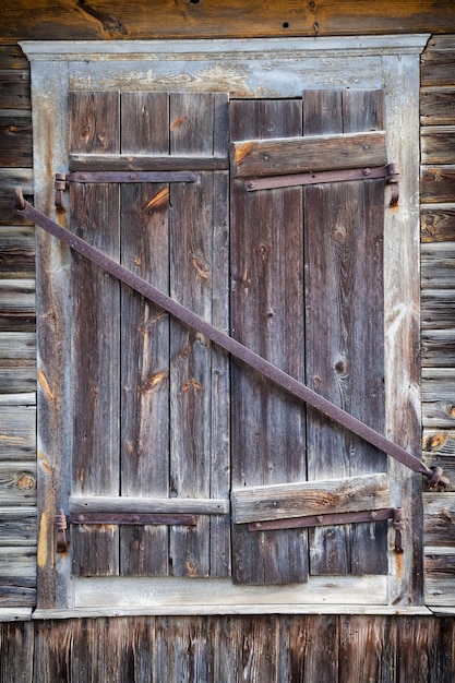 Закрытое деревенское окно старого деревянного дома