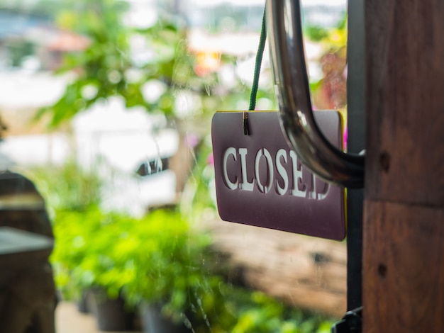 Closed sign board hanging on glass door