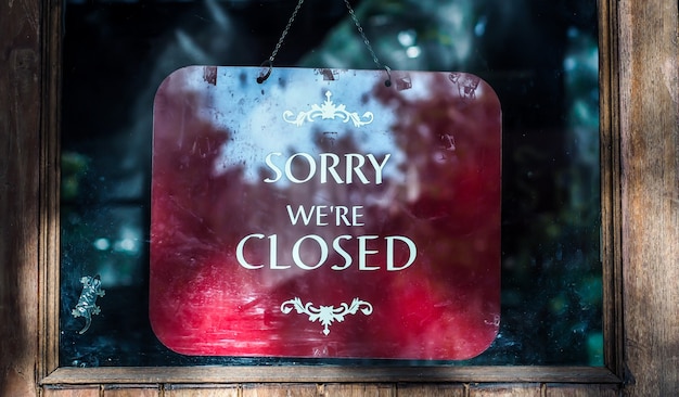 Photo closed sign in shop window. vintage wooden door background