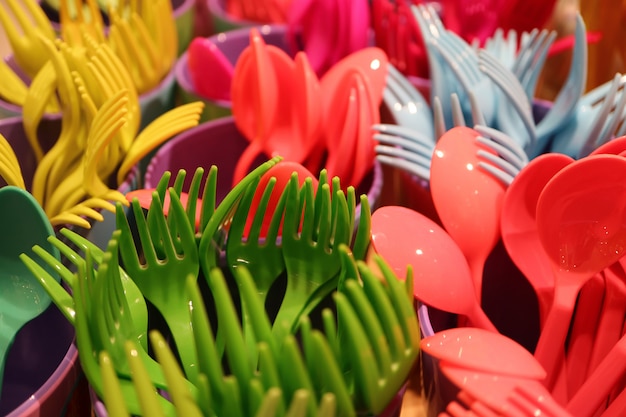 セレクティブフォーカスの多色プラスチック製食器類の束をクローズアップ