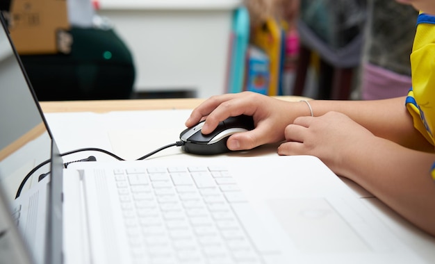 Photo closed up of mouse with kid hand and notebook