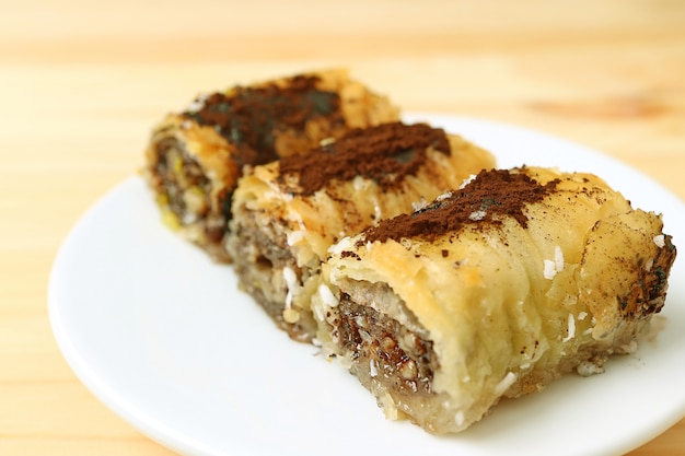 Closed up a place of three pieces of delicious Baklava sweets served on wooden table