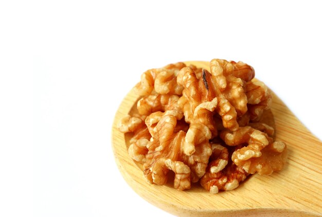 Closed up Raw Walnut Kernels on Wooden Ladle Isolated on White