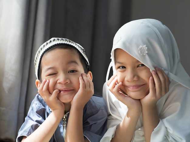 Closed up shot of asian muslim kids.young sister and brother
sibling in muslim traditional dress.happy and looking to
camera.concept of happy kid in ramadan or family bonding.