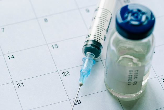 Closed vial with vaccine and empty syringe