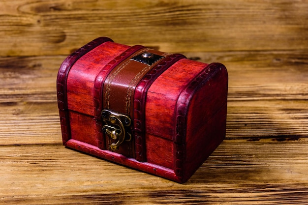 Closed vintage chest from red wood on wooden background