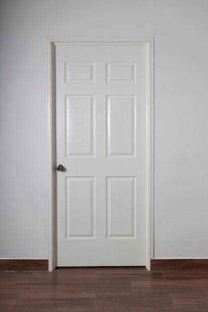 Фото Закрытая белая дверь на серой стене