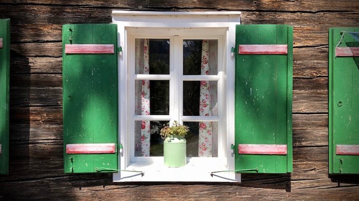 Photo closed window of old traditional austrian alpine house with green shutters