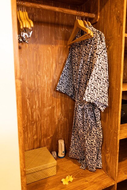 A closet with a robe and a bottle of shampoo.