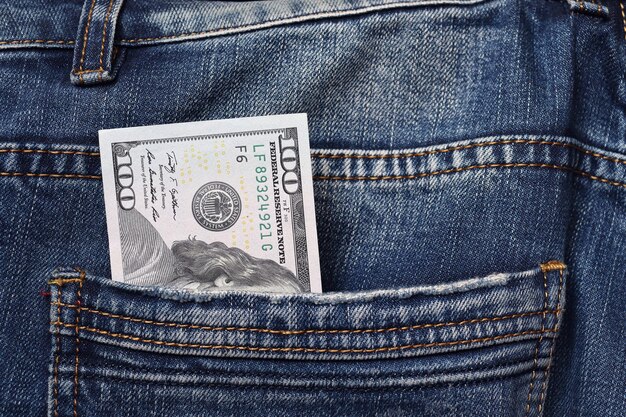 Primo piano di una banconota da 100 in una tasca dei jeans