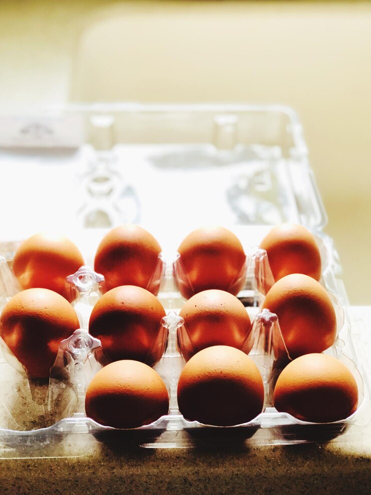 Photo closeup of 11 eggs in the egg container on a table