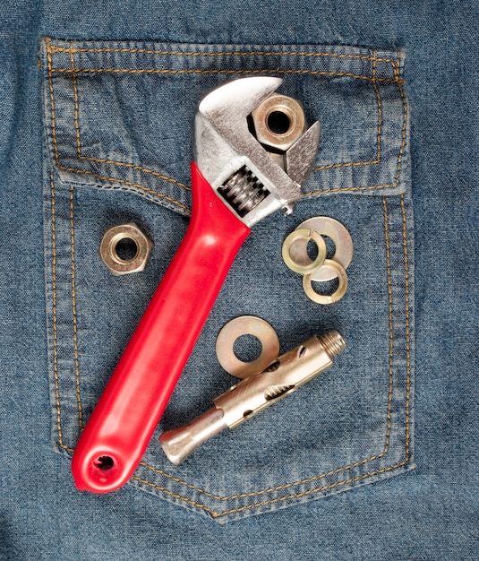 closeup of an adjustable wrench on jean 