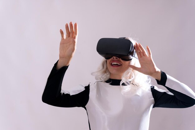 Closeup of adult woman gesturing with virtual reality glasses metaverse on a white background