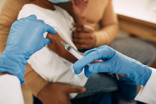 Closeup of African American child receiving a vaccine at pediatrician's office