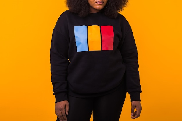 Closeup of african american girl with an afro hairstyle portrait on yellow background street fashion