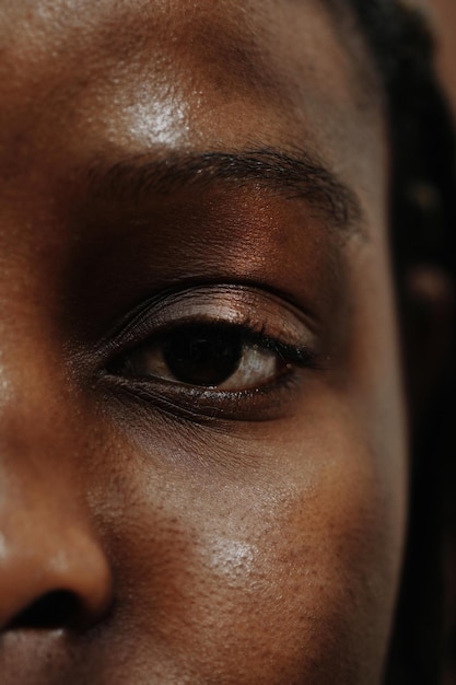 Closeup of african young woman with dark brown eyes looking at camera