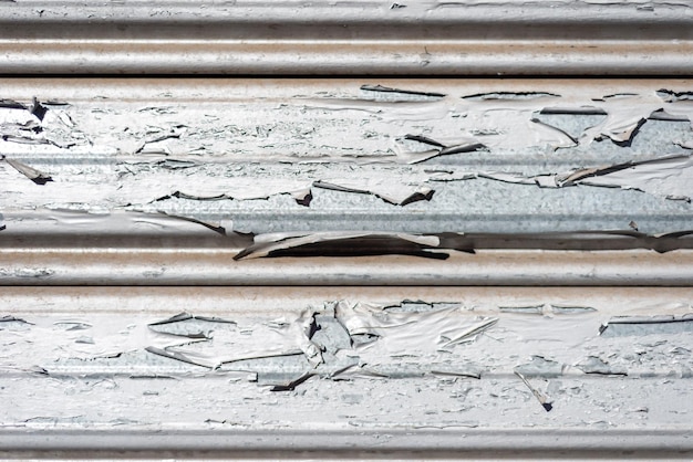Closeup aged garage metal door texture with peeling paint