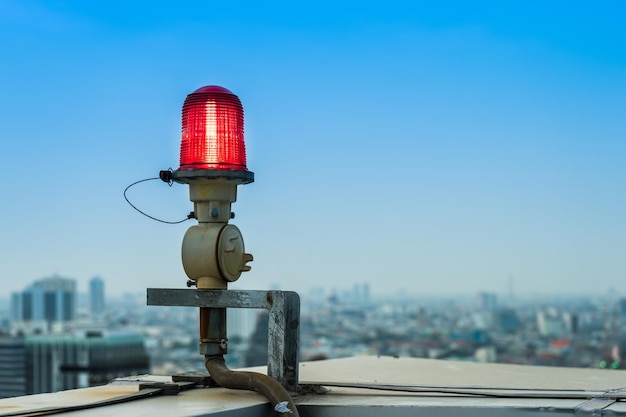 Closeup of an aircraft warning light on top of a highrise of building in evening time