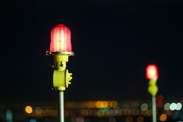 Closeup of an aircraft warning light on top of a highrise of building in night time